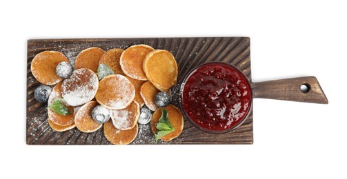 Photo of Wooden board with cereal pancakes, jam and blueberries on white background, top view