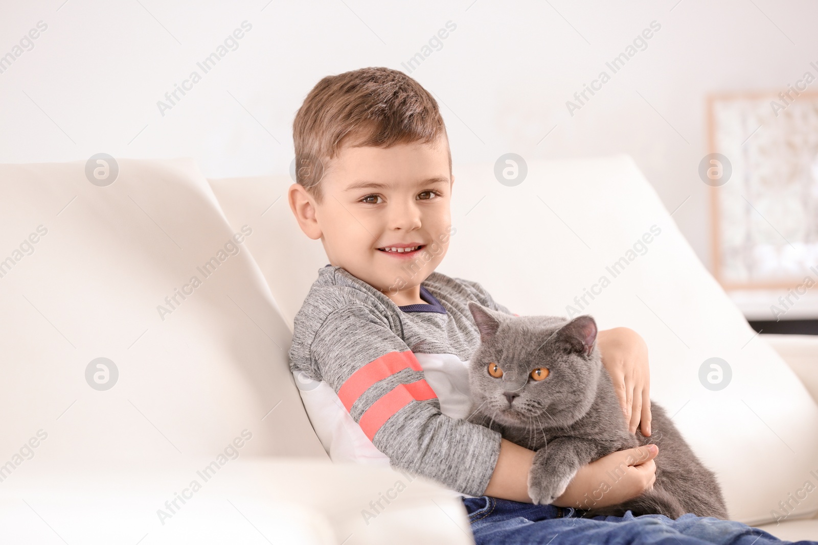 Photo of Cute little child with cat at home