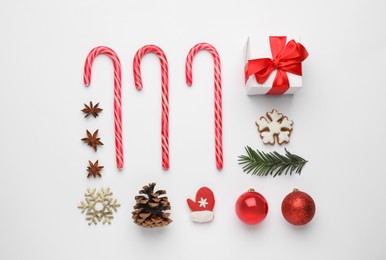Flat lay composition with sweet candy canes and Christmas decor on white background