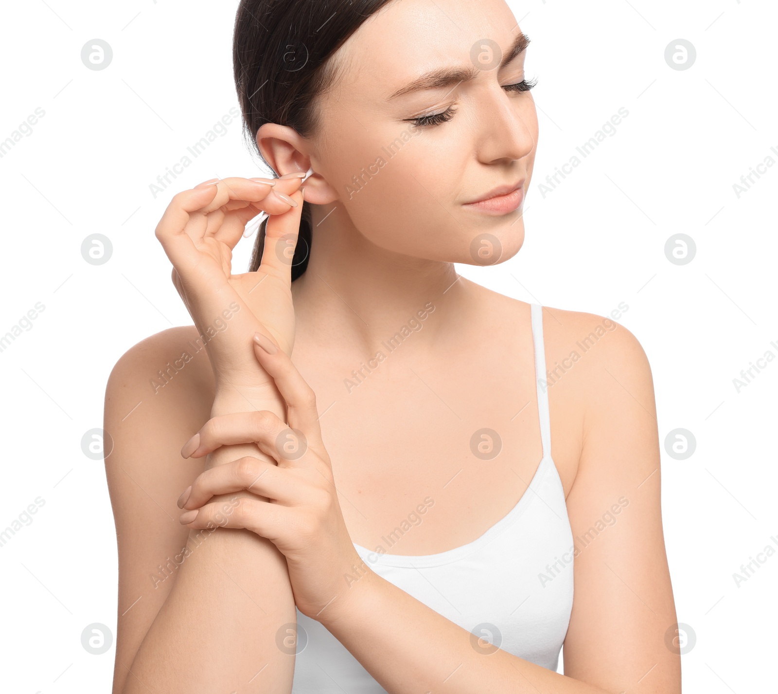 Photo of Young woman cleaning ear with cotton swab on white background