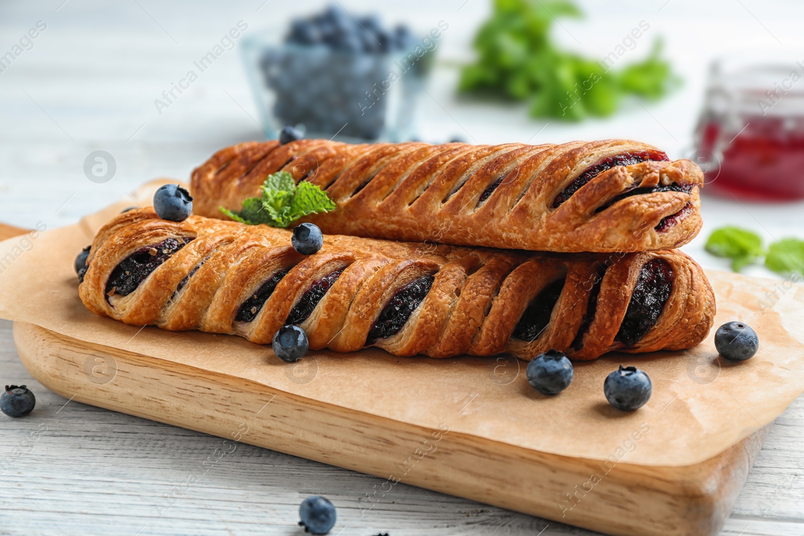 Photo of Fresh delicious puff pastry with sweet berries served on white wooden table