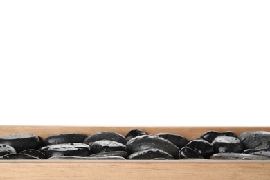 Photo of Wooden tray with wet spa stones against white background