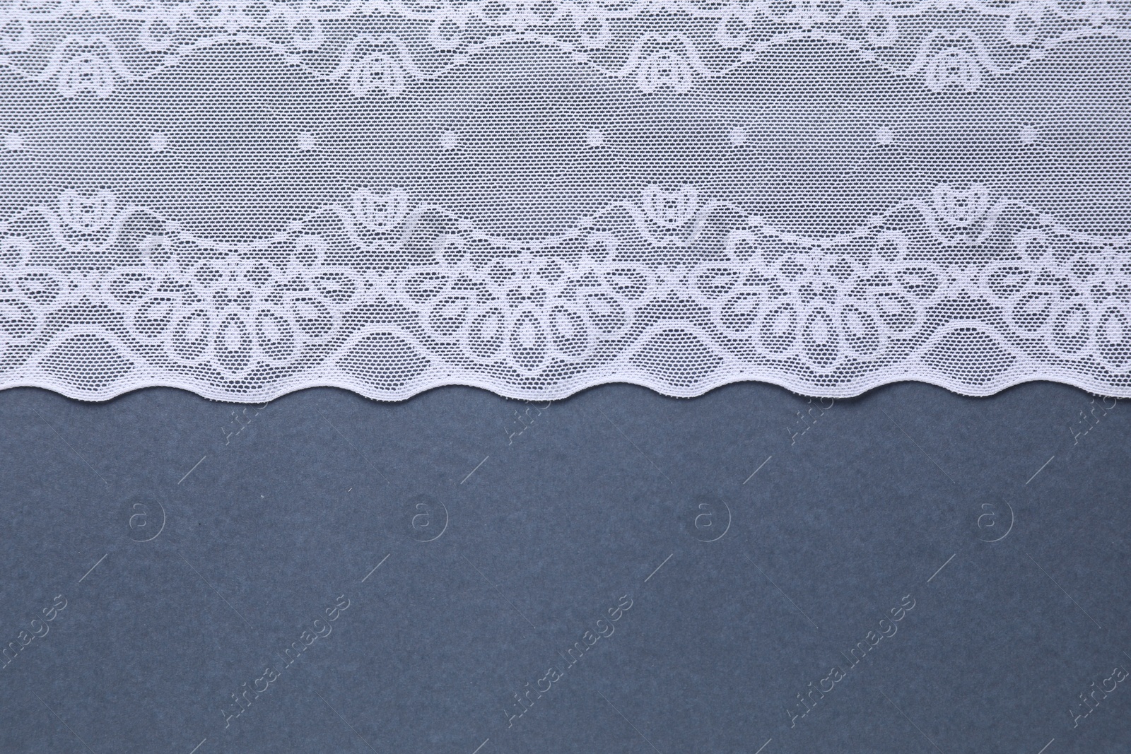 Photo of White lace on light blue background, top view. Space for text