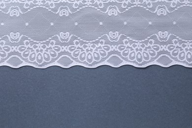 White lace on light blue background, top view. Space for text