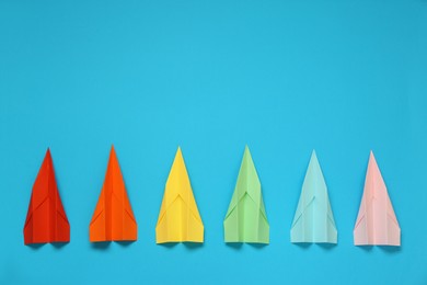 Flat lay composition with different paper planes on light blue background, space for text