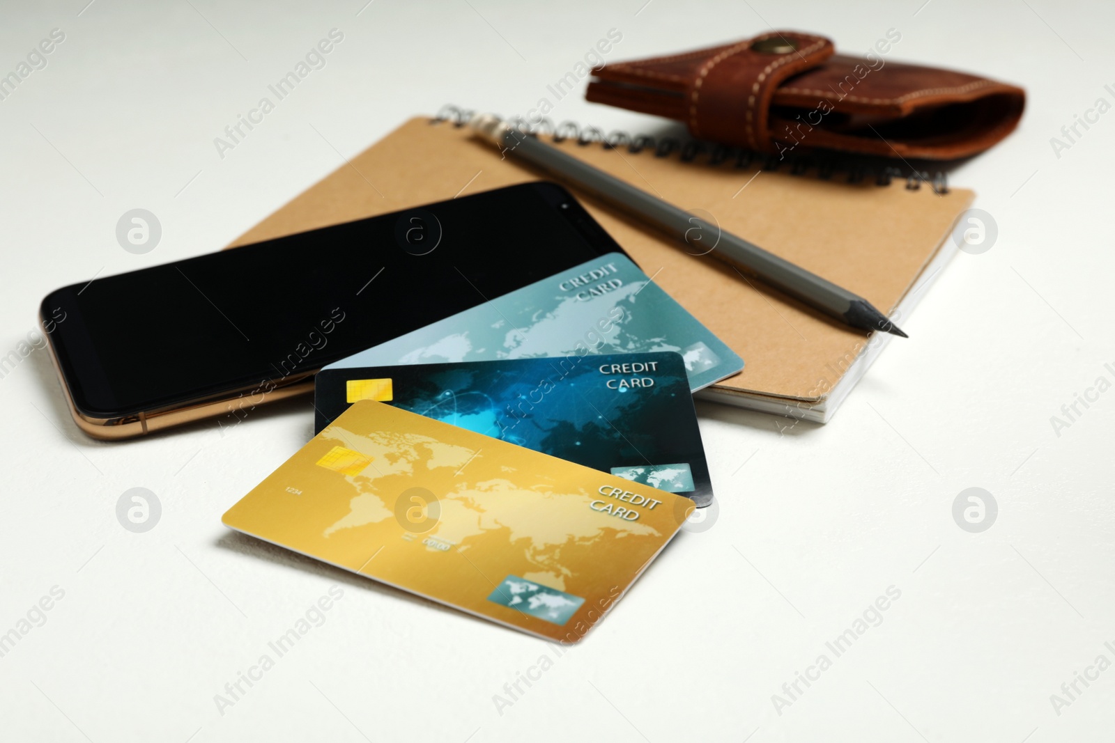 Photo of Credit cards, smartphone and notebook on white table