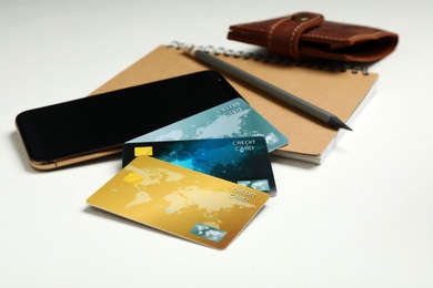 Credit cards, smartphone and notebook on white table