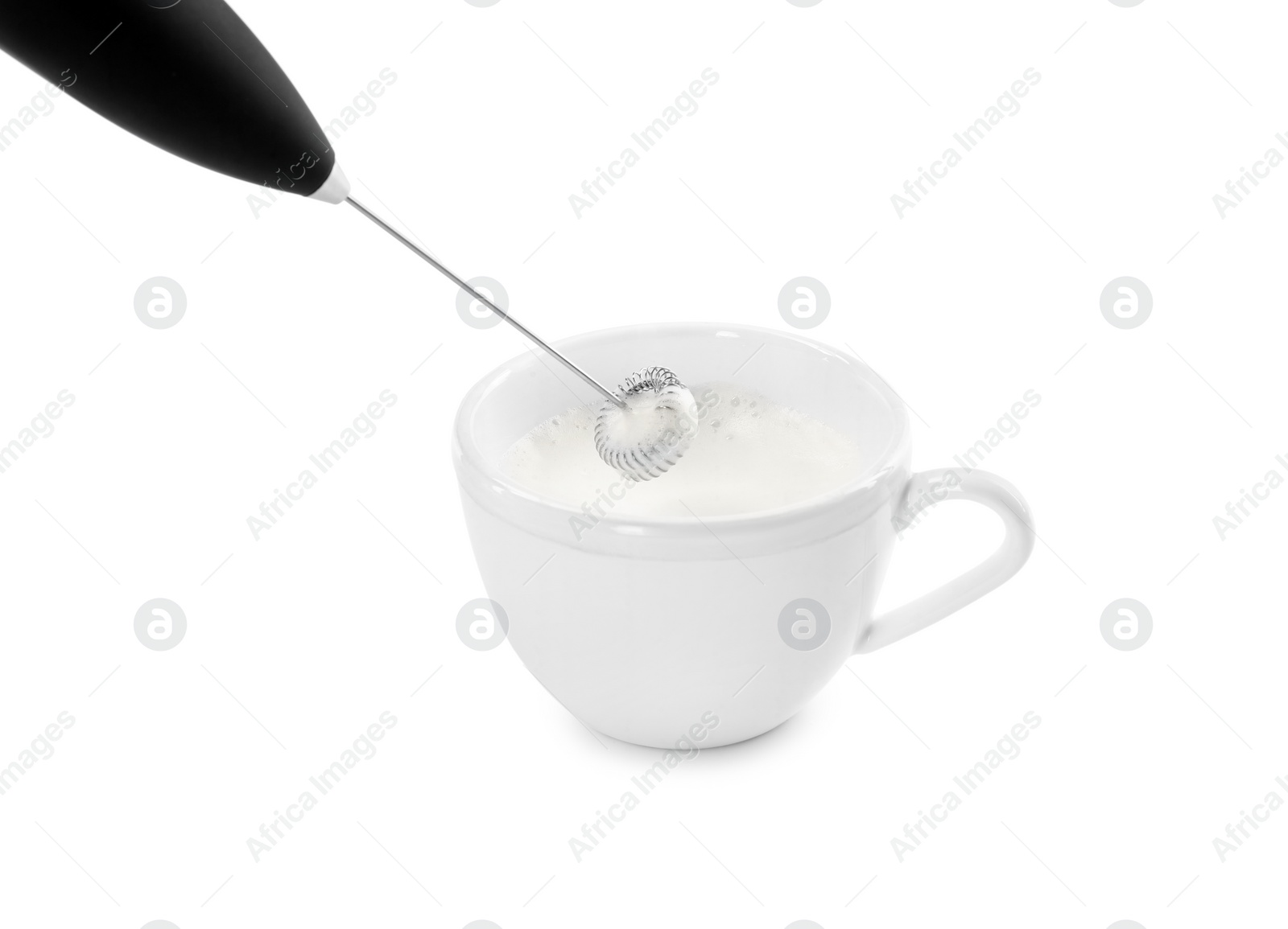 Photo of Whisking milk in cup with mini mixer (frother wand) isolated on white