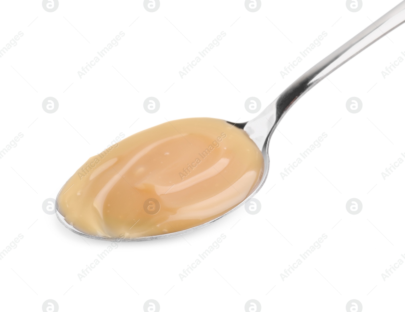 Photo of Spoon with tasty salted caramel isolated on white