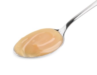 Photo of Spoon with tasty salted caramel isolated on white