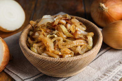 Photo of Tasty fried onion on wooden table, closeup