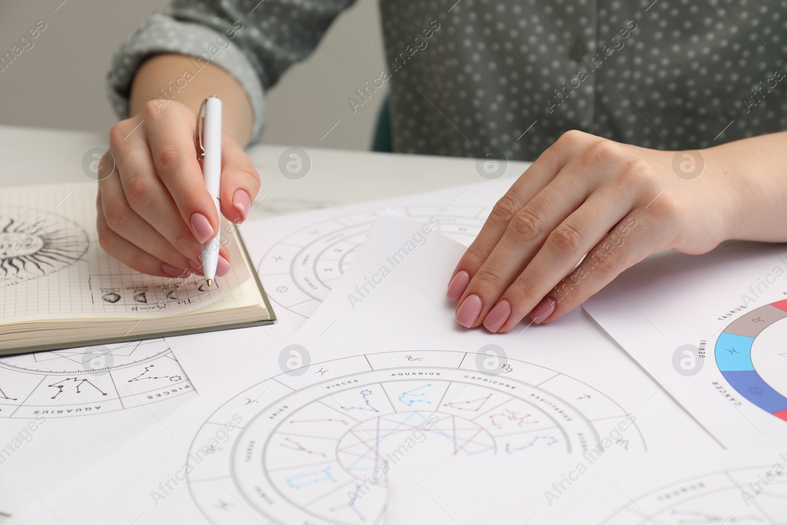 Photo of Astrologer using zodiac wheel for fate forecast at table, closeup. Fortune telling