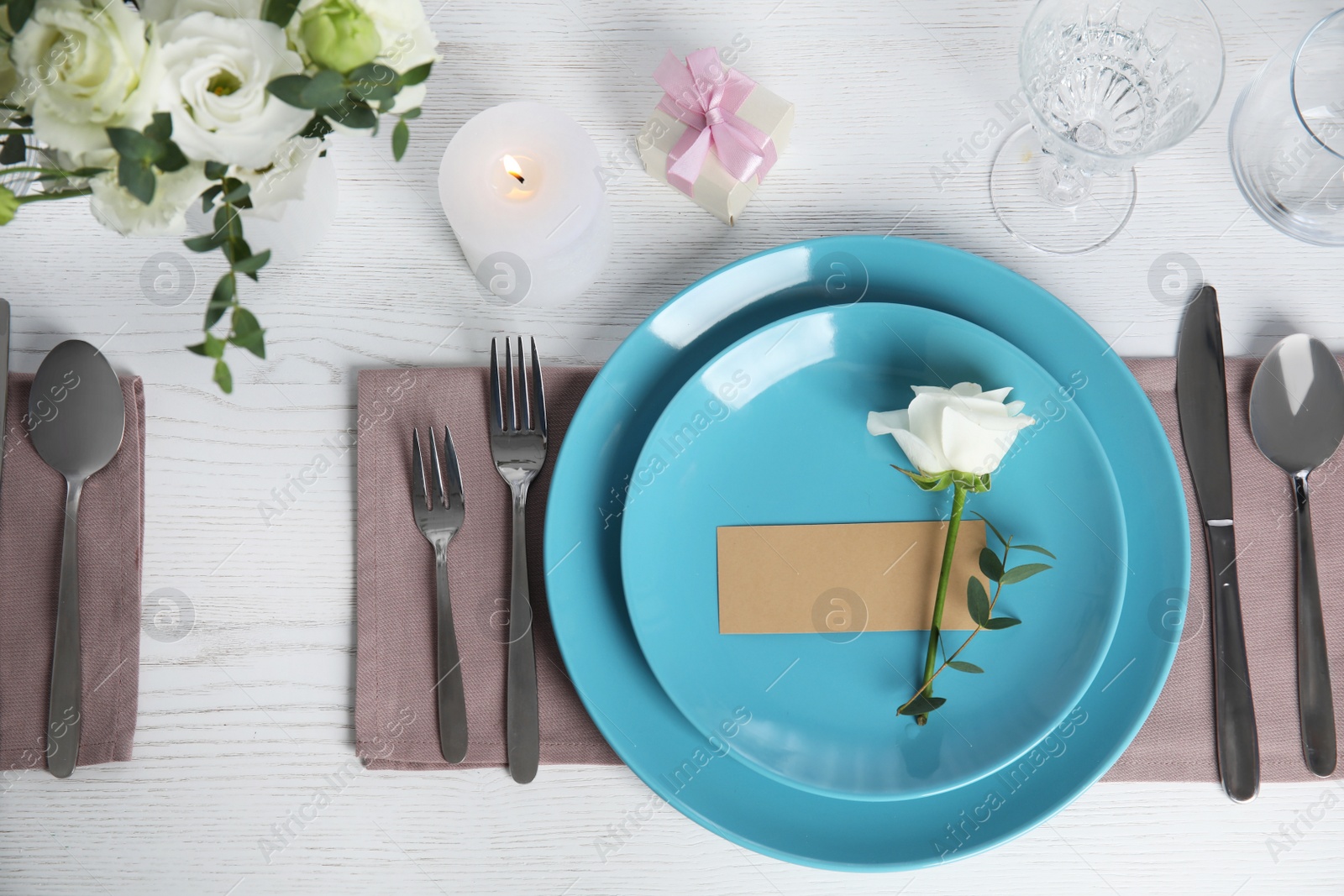 Photo of Elegant festive table setting with blank card on white wooden table, flat lay
