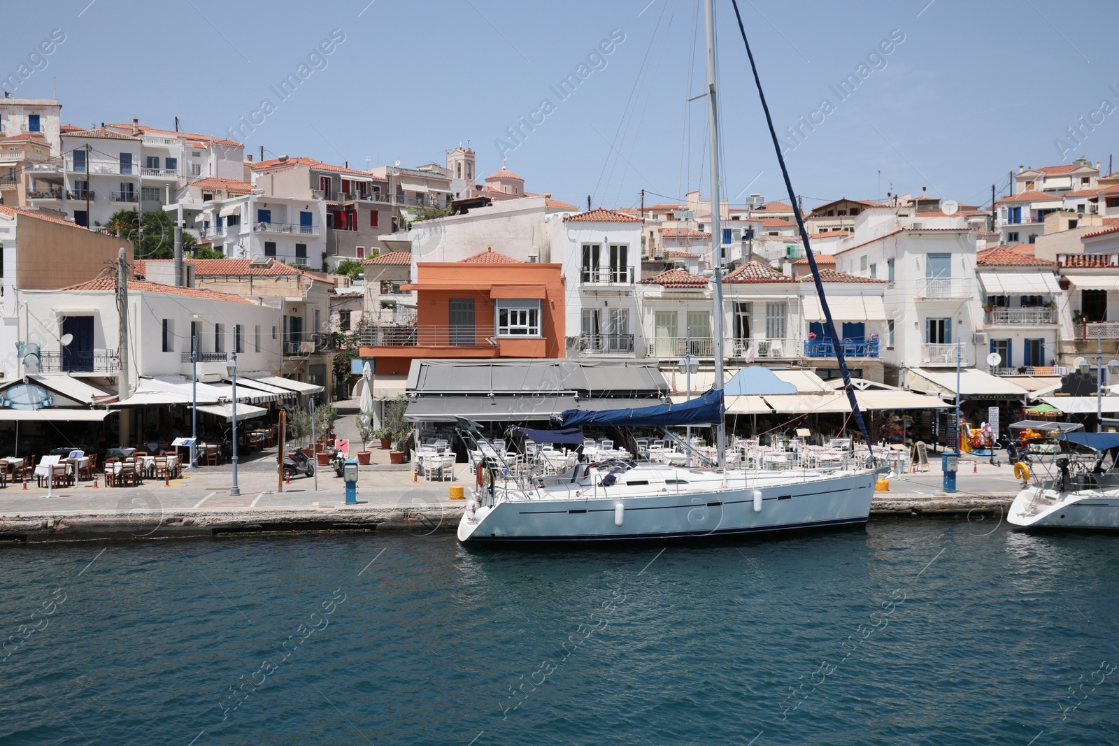 Photo of Beautiful view of coastal city with sailboat on sunny day