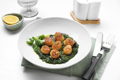 Delicious fried scallops with tasty sauce and corn salad in bowl on white table, closeup