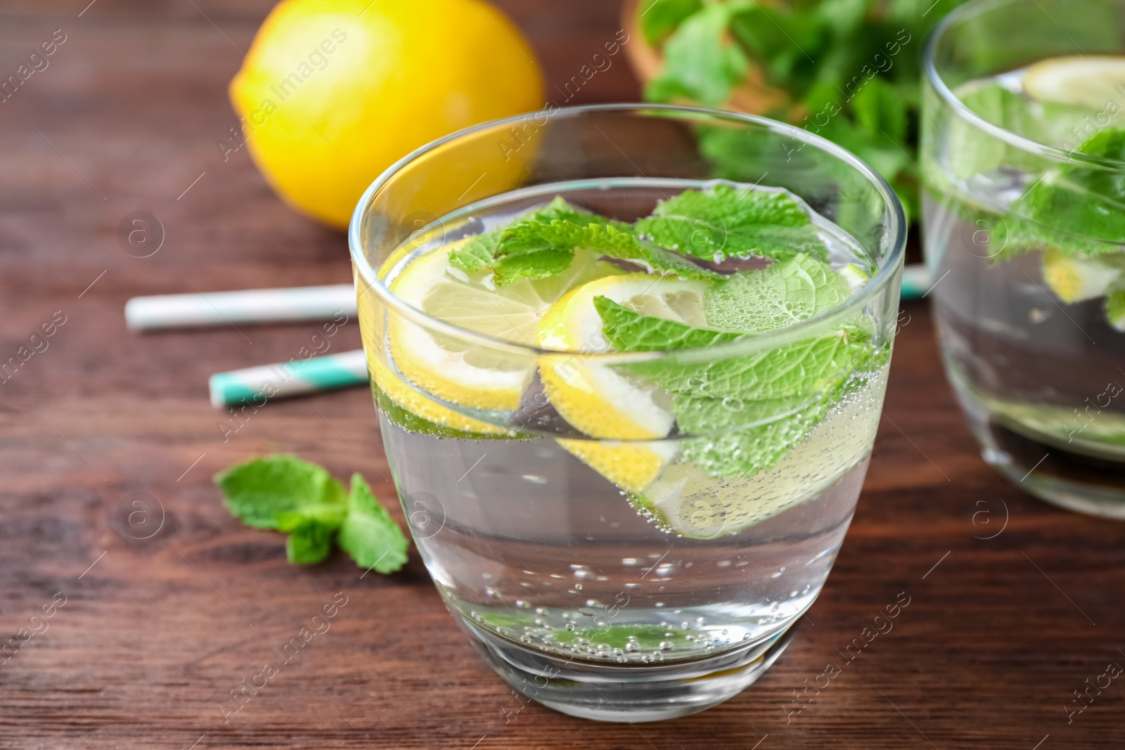 Photo of Tasty refreshing lemonade on wooden table, closeup. Summer drink