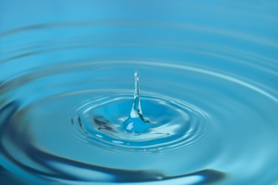 Photo of Splash of blue water with drop, closeup