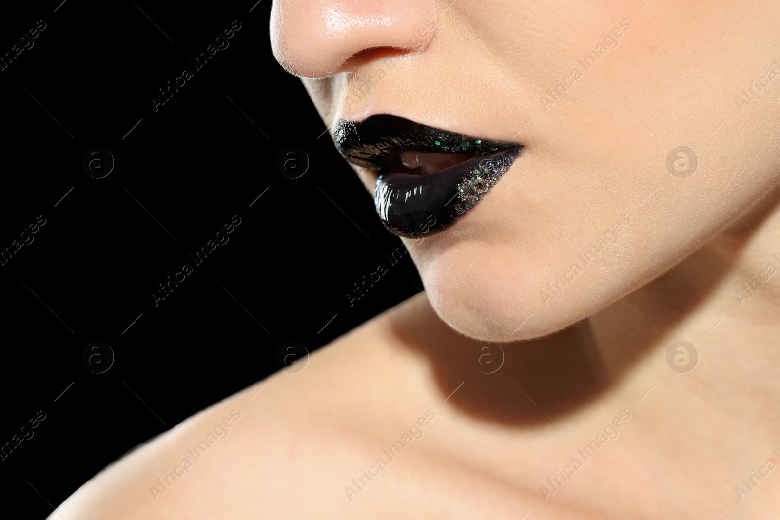 Photo of Beautiful young model with creative lips makeup on black background