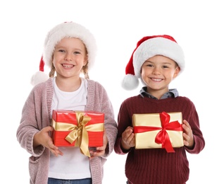 Photo of Happy little children in Santa hats with gift boxes on white background. Christmas celebration