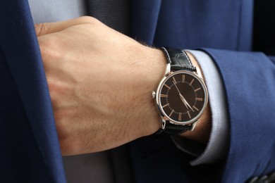 Photo of Businessman in suit with luxury wrist watch, closeup