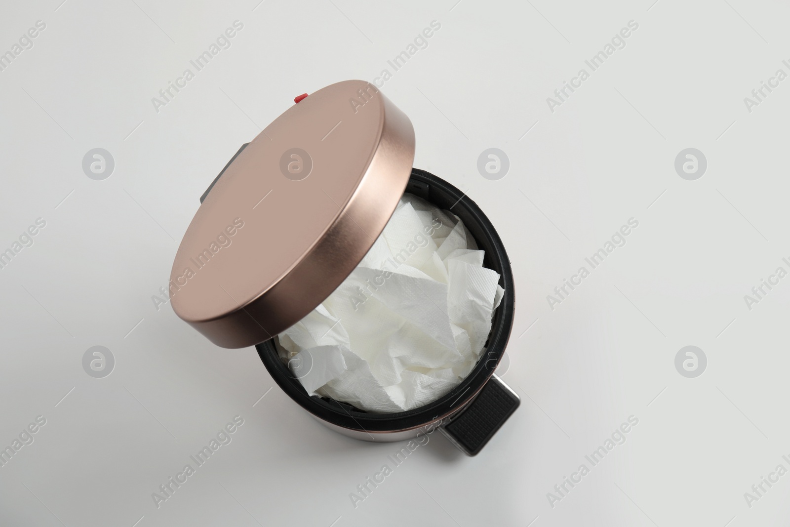 Photo of Trash bin with used toilet paper on white background, top view