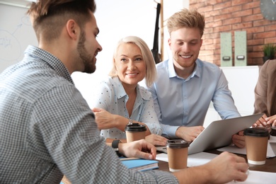 Photo of Business people discussing work matters at table in office. Professional communication