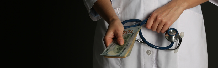 Image of Doctor with bribe and stethoscope on black background, closeup. Banner design