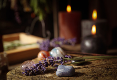 Photo of Gemstones and healing herbs on wooden board