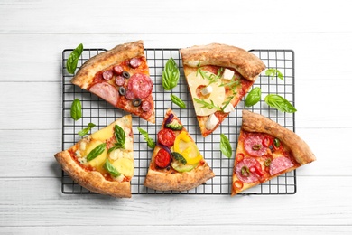 Photo of Slicesdifferent delicious pizzas on white wooden table, flat lay