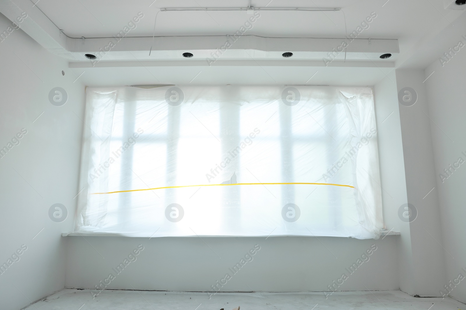 Photo of Big window covered with plastic film in room