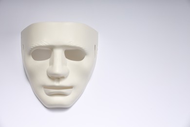 Photo of Theater arts. Plastic mask on white background, top view. Space for text