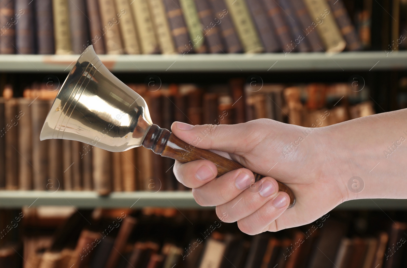 Image of Woman with school bell in library, closeup