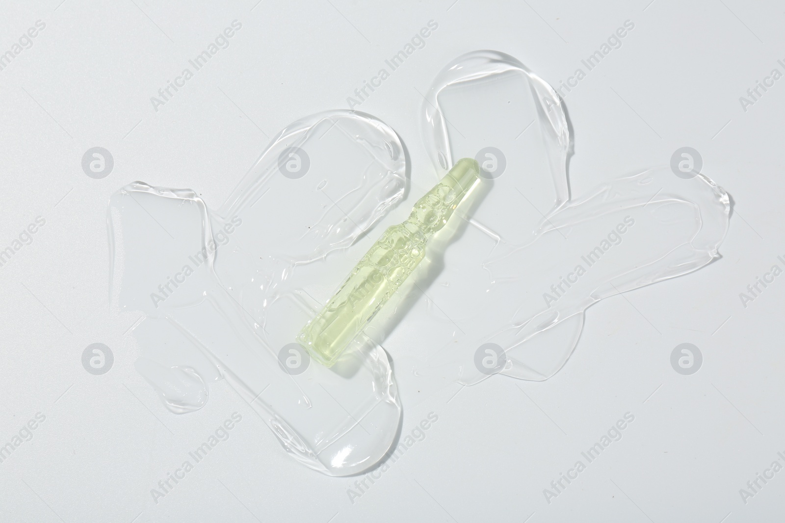 Photo of Skincare ampoule on white surface with gel, top view