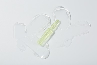 Photo of Skincare ampoule on white surface with gel, top view