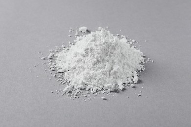 Photo of Heap of calcium carbonate powder on light grey table, closeup