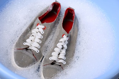 Photo of Washing pair of sport shoes in plastic basin