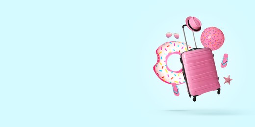 Image of Pink suitcase and beach accessories flying on pale light blue background. Banner design with space for text