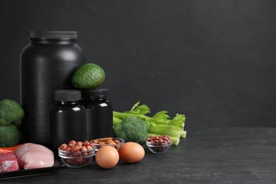 Photo of Set of products rich in amino acids and supplements on black table. Space for text
