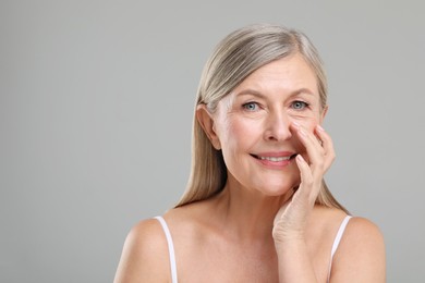 Photo of Beautiful mature woman with healthy skin on gray background, space for text