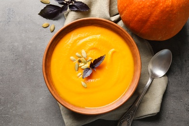 Photo of Flat lay composition with bowl of pumpkin soup on gray background