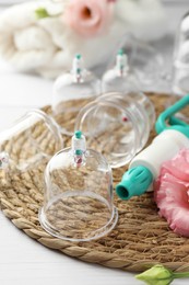 Photo of Plastic cups and hand pump on white table. Cupping therapy