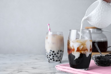 Photo of Preparing bubble milk tea with tapioca balls on white marble table. Space for text