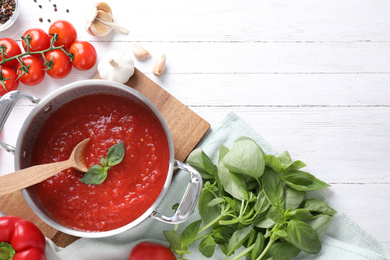 Photo of Delicious tomato sauce on white wooden table, flat lay. Space for text