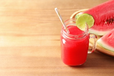 Photo of Summer watermelon drink in mason jar, sliced fruit and space for text on table