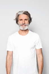 Photo of Portrait of charming mature man on light grey background