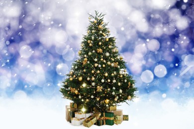 Image of Beautifully decorated Christmas tree on blue background. Bokeh effect