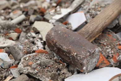 Photo of Sledgehammer on pile of broken bricks, closeup
