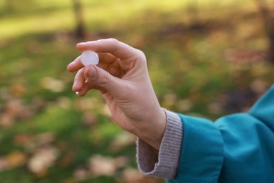 Photo of Woman holding hail grain after thunderstorm outdoors, closeup