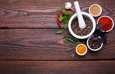 Photo of Flat lay composition with mortar and different spices on wooden table, space for text