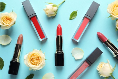 Photo of Flat lay composition with lipsticks and roses on color background